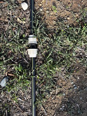 Yerdeki metal bir çubuğun dikey görüntüsü.