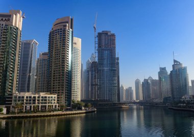 Dubai Marina gökdelenleri ve açık mavi gökyüzü altında deniz manzaralı gökdelenler, BAE 'de lüks kentsel mimari.