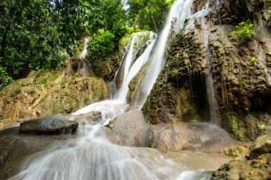 Endonezya 'daki Air Terjun Pantai Pelang manzarası. Tatlı su akıntıları dokulu kireçtaşı uçurumlarından sahile sadece birkaç adım uzaklıktaki sakin, ormanlı bir havuza akar..