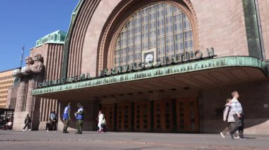 Finlandiya 'daki Helsinki Merkez Tren İstasyonu binasının ana girişinin önünde yürüyen insanlar. Bina Avrupa ülkesinin tarihi bir simgesidir ve 1914 yılında tamamlanmıştır. Ayrıca Finlandiya 'nın en işlek tren istasyonudur..