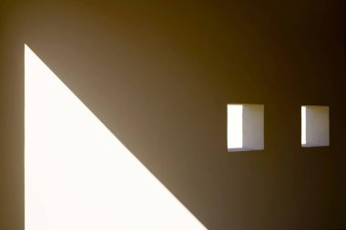 Geometrik güneş ışığı ve kare oyukları olan minimalist duvar