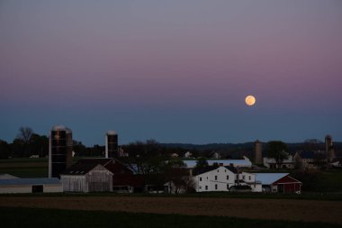 Lancaster 'da tarım arazisi üzerinde ay ve gün batımı, PA