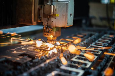Dijital yazılım kontrolüyle lazer kesme işlemi. Lazer kesici kafa metal bir levhayı keser ve kıvılcımlar gönderir. Yüksek kalite fotoğraf