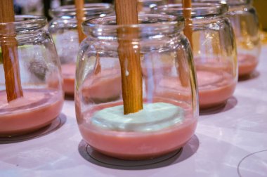 Ev için ahşap fitili olan dekoratif kokulu mumlar yapma süreci. Şeffaf cam dikişlerinde el yapımı mumlar. Yüksek kalite fotoğraf