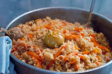 Özbek ulusal yemek pilavı büyük bir tencerede hazırlanıyor. Bir sürü havuç ve sarımsak. Yüksek kalite fotoğraf