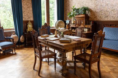 Ahşap Mobilya Kitapları ve Klasik Dekoratif Detaylarla Klasik Çalışma Odası. Klasik bir iç mekanda ahşap mobilyalar, kitaplar ve dekoratif nesnelerle geleneksel çalışma odası. Sakin entelektüel atmosfer eğitimi, tarihi ve