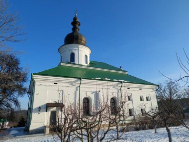 Barok kilisesi yeşil çatılı ve karlı bir kış bahçesinde kahverengi kubbeli, Ukrayna