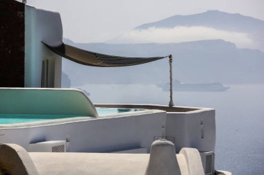 Sonsuzluk havuzu ve deniz manzaralı boş Santorini terası.