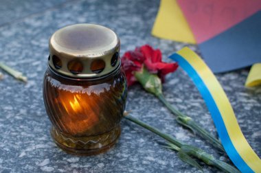 Mum, karanfil ve bayraklarla anıt.