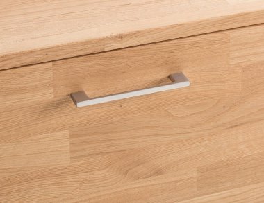 Wooden drawer with a handle close view photo, wooden furniture elements background. Furniture details