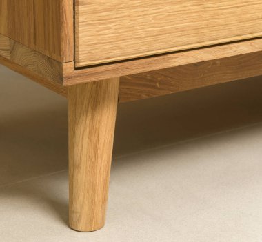 Wooden cupboard leg close view photo, wooden eco furniture elements background. Solid wood furniture leg