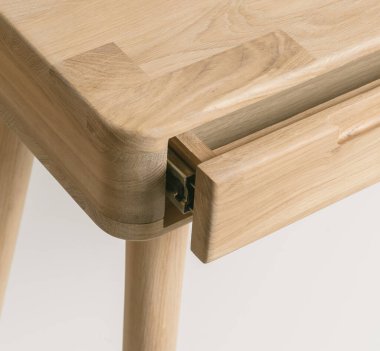 Wooden table corner with drawer and leg close view photo, wooden eco furniture elements background. Solid wood furniture leg