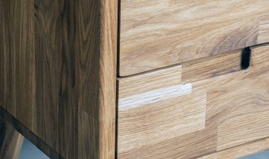 Bedside table with drawers close view photo, wooden eco furniture elements background. Solid wood furniture details