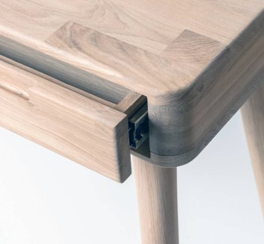 Wooden table corner with drawer and leg close view photo, wooden eco furniture elements background. Solid wood furniture leg