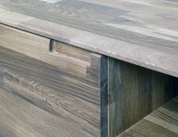 Wooden drawer with a handle close view photo, wooden furniture elements background. Furniture details