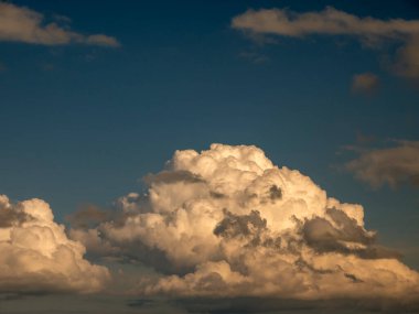Günbatımı arka planında tek bir kabarık bulut. Yumuşak kümülüs bulut şekilli fotoğraf