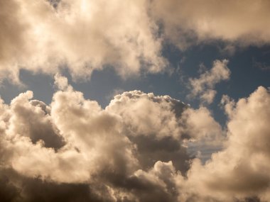 Gün batımı gökyüzünde kabarık bulutlar. Yumuşak kümülüs bulut şekilli fotoğraf, kasvetli bulutlu arka plan