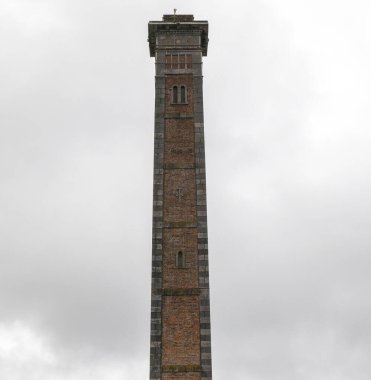 Beyaz zemin üzerinde yüksek tuğla kule yapısı