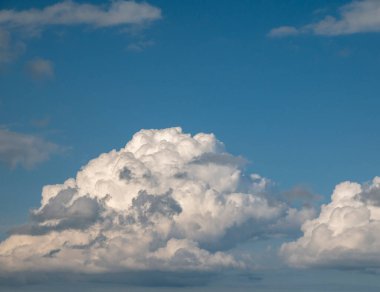 Beyaz ve gri kümülüs bulutları arka planda mavi yaz gökyüzü arka planında