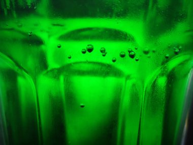 Yeşil cam soyut arkaplan, yakın görüş. Kabarcıklı yeşil sıvı