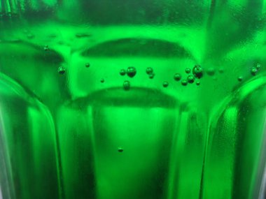 Yeşil cam soyut arkaplan, yakın görüş. Kabarcıklı yeşil sıvı