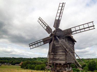 Yel değirmeni ahşap, fırtınalı gökyüzü altında eski fırıldak duvar kağıdı ayakta yapılan