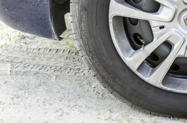 Araba tekerleği ve yerdeki parmak izleri, kavramsal fotoğraf. Araç tekerleği yakın görünüm