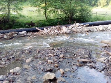 Siyah Endüstriyel boru ve dağlarda küçük bir nehir