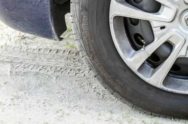 Araba tekerleği ve yerdeki parmak izleri, kavramsal fotoğraf. Araç tekerleği yakın görünüm