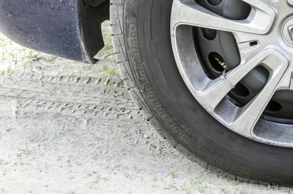 Araba tekerleği ve yerdeki parmak izleri, kavramsal fotoğraf. Araç tekerleği yakın görünüm