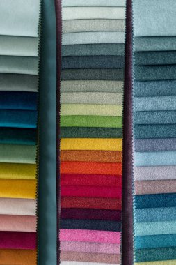 Çok renkli kumaş örnekleri dikey olarak sıralanmış, ışıktan karanlığa çeşitli renkler sergiliyorlar. Örnekler, muhtemelen döşeme için, maviler, yeşiller ve griden canlı kırmızılar, pembeler ve sarılar arasında değişiyor..