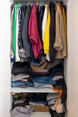 Aşırı dolu gardırop kıyafetleri rafları yığdı. Kaos ortamı azaldı. Tüketim tüketimi birikti.
