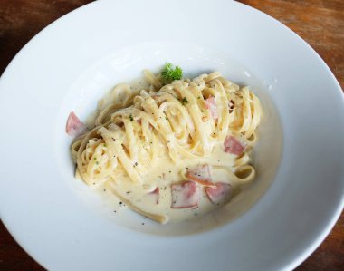 Kremalı fettucine carbonara, klasik İtalyan pastırmalı makarna, beyaz tabakta..