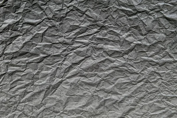 Buruşuk ve kumlu desenli koyu gri bir duvar.