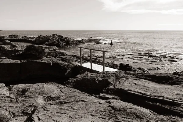 Akdeniz manzarası ve Saint-Raphal 'daki kayalıklarda ahşap bir geçit, sepya siyah ve beyaz efektli.