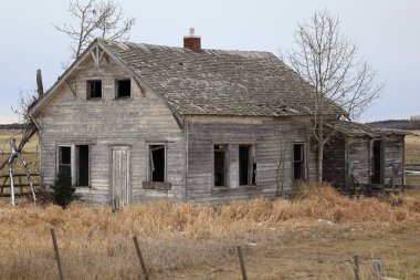 Çayırda terk edilmiş eski bir ahşap ev. Eski çiftlik günlerinin bir görüntüsü..