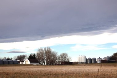 Sonbaharda ya da hasattan sonra sonbaharda bir çiftlik. Kulübeler ve tahıl ambarları kışı geçirmeye hazır nöbetçiler gibi duruyor. Bir kara bulut yığını geliyor ve açık mavi gökyüzünün yerini alıyor..