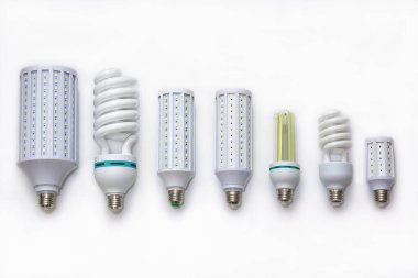 Çeşitli LED mısır lambaları satırı ve temiz beyaz arka planda sıkışık floresan sarmal ampuller; modern ışıklandırma seçenekleri; verimlilik; tasarım ve ev gücü tasarrufu