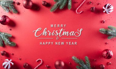 Noel kompozisyonu. Firavun ağacı dalları, kırmızı top ve kırmızı arka planda yıldızlar. Noel, kış, yeni yıl konsepti.