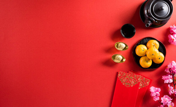 Chinese new year festival decorations pow or red packet, orange and gold ingots or golden lump on a red background. Chinese characters FU in the article refer to fortune good luck, wealth, money flow.