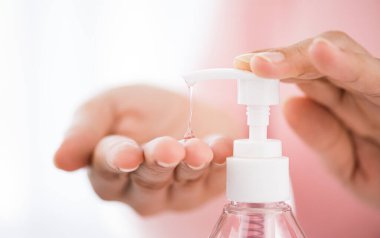 Coronavirus hastalığının (COVID-19) önlenmesi için çamaşır deterjanı jeli pompası kullanan eller için hafif bir odak noktası. Sağlık ve dezenfeksiyon konsepti.