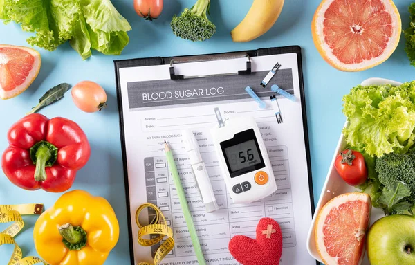 Top view of healthy food in plate with stethoscope and red heart for cholesterol diet and diabetes control on pastel blue background. World health day and medical concept.