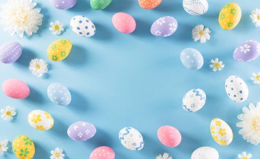 Mutlu Paskalyalar! Pastel mavi arka planda çiçekli Paskalya yumurtaları. Paskalya Günü için hediyeler ve selamlar zamanı kutluyor. Düz yatış, üst görünüm.