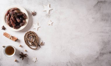 Ramazan yemeği ve içecek konsepti. Ramazan ağacı tespihi, çay ve koyu arkaplanda meyveler..