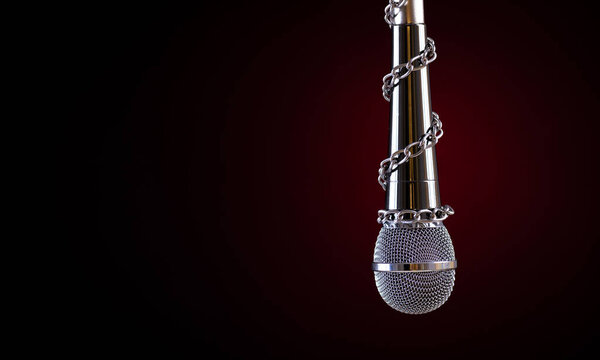 World press freedom day concept. Microphone with a chain, depicting the idea of freedom of the press or freedom of expression on dark background.