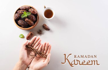 Ramazan Kareem arkaplanının masa üstü görüntüsü, meyve, kahve ve tespih ile el tarihleri.