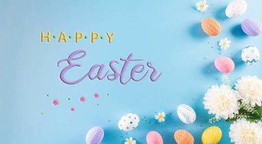 Mutlu Paskalyalar! Pastel mavi arka planda çiçekli bir sürü Paskalya yumurtası. Paskalya Günü için hediyeler ve selamlar zamanı kutluyor. Düz yatış, üst görünüm.