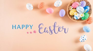 Mutlu Paskalyalar! Pastel arka plandaki yuvada bir sürü Paskalya yumurtası. Paskalya Günü için hediyeler ve selamlar zamanı kutluyor. Düz yatış, üst görünüm.