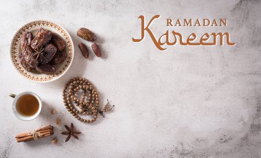 Ramazan yemeği ve içecek konsepti. Ramazan ağacı tespihi, çay ve koyu taş arka planda meyveler..