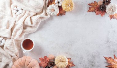 Sonbahar kompozisyonu. Bir fincan kahve, pamuk çiçekleri, sonbahar yaprakları ve taş zeminde süveter. Düz konum, kopyalama alanı olan üst görünüm.